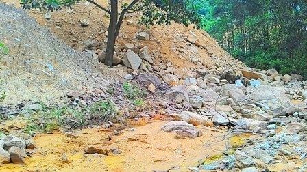 Buộc mỏ đá gây bồi lấp dòng chảy phải xử lý hậu quả - 1 Đất đá thải của mỏ đá Việt Nhật tràn ra làm tắc dòng chảy phía dưới