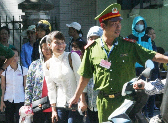 Công an phường dẫn hàng trăm thí sinh qua đường phố đông nghịt - 3 Nụ cười tươi rói của 1 nữ sĩ tử khi được Đại úy Hùng dẫn qua đường