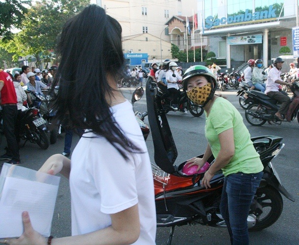 Bố mẹ động viên con bước vào kỳ vượt vũ môn - 3 Mẹ cất mũ bảo hiểm cho con và ngoái đầu chúc con làm bài tốt