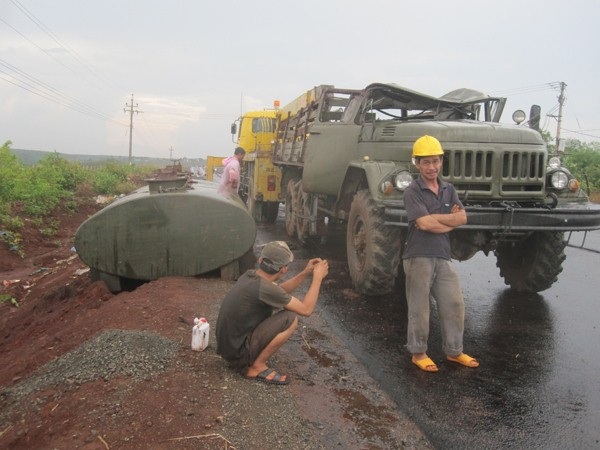 Cách đó không xa một chiếc xe chở xăng cũng đã bị lật xuống lề đường.