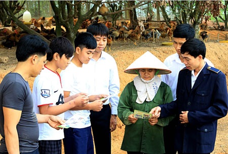 Vẫn phát hiện gà lậu ồ ạt vào Việt Nam - 1 Cán bộ hướng dẫn người chăn nuôi vệ sinh chuồng trại bằng các dung dịch sát khuẩn. Ảnh: H.H