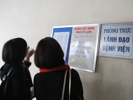 Người dân xem thông tin về đường dây nóng tại BV Bạch Mai.