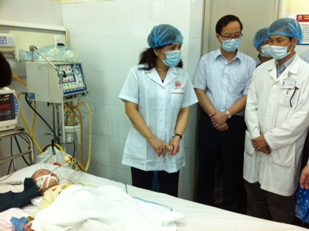Vì sao Hà Nội chưa công bố dịch sởi? - 1 Bộ trưởng Bộ Y tế thăm bệnh nhi biến chứng viêm phổi điều trị tại BV Nhi Trung ương. Ảnh: H.Hải