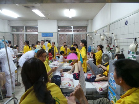 Bộ trưởng Bộ Y tế thăm hỏi bệnh nhi. Bà ân cần động viên người mẹ, dặn dò người mẹ cố gắng,