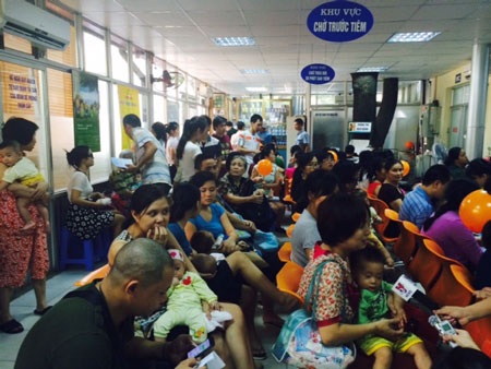 Người dân ngồi chờ tiêm vắc xin dịch vụ 6 trong 1 cho trẻ. Ảnh: H.Hải