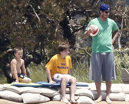 Beckham lộ “bụng phệ” khi chơi đùa với các con trai - 1