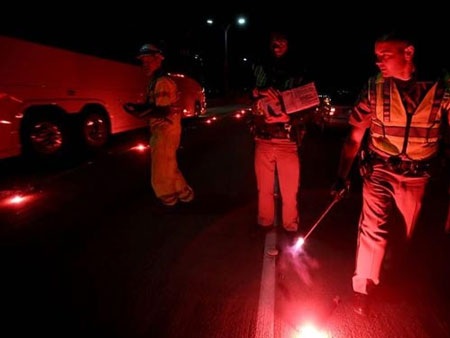 Cảnh sát đang điều tra hiện trường vụ cháy xe. Ảnh: AP