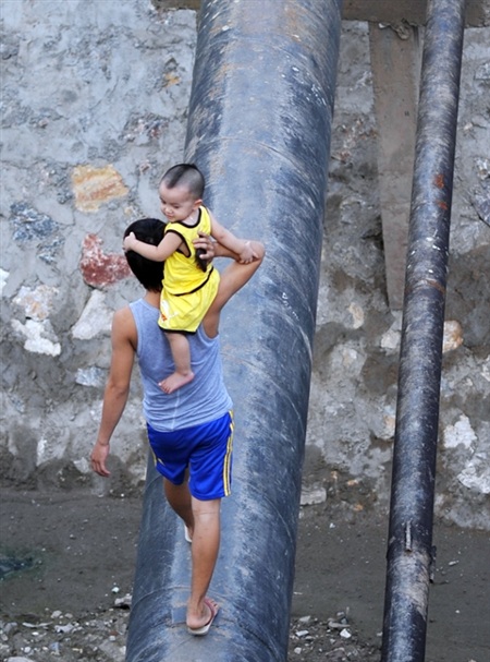 Người dân Hà Nội “làm xiếc” trên sông - 5 Khi Cầu Khỉ chưa được hoàn thiện, người dân vẫn phải chọn lối đi nguy hiểm này để qua sông Sét.