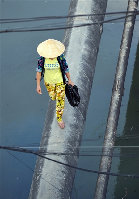 Người dân Hà Nội “làm xiếc” trên sông - 7 Khi Cầu Khỉ chưa được hoàn thiện, người dân vẫn phải chọn lối đi nguy hiểm này để qua sông Sét.