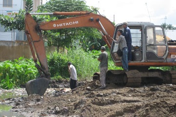 Dùng máy xúc san bằng mồ mả vô danh - 1