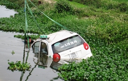 Taxi "vọt" vệ đường, lao xuống sông - 1