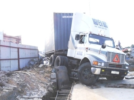 Xe container nằm vắt ngang rào chắn công trình  - 4