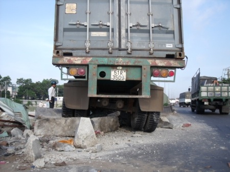 Xe container nằm vắt ngang rào chắn công trình  - 3