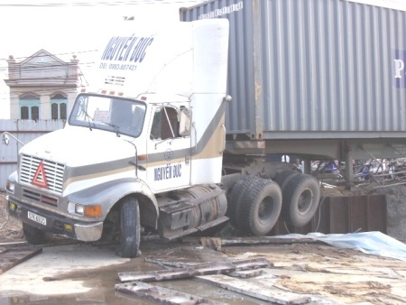 Xe container nằm vắt ngang rào chắn công trình  - 2