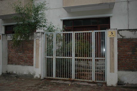 Một căn biệt thự để hoang lâu ngày đã bắt đầu có cây cỏ mọc dại mọc cao hơn cổng