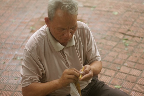 Người Hà Nội cuối cùng kiếm sống bằng nghề "khắc bút tặng phẩm" - 1 Ông Quý ngồi hành nghề khắc bút bên Hồ Gươm