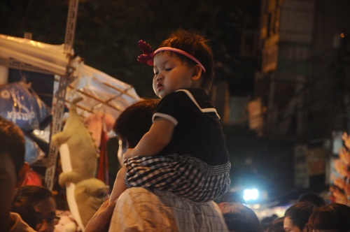  Trẻ nhỏ được người lớn cõng lên vai vì đường quá đông