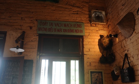 Câu khẩu hiệu và đồ vật thời chiến được treo trên tường gạch thô