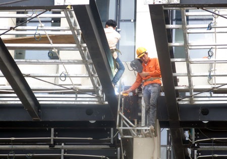 Đại biểu Quốc hội ngồi thử ghế tại phòng họp Quốc hội mới - 5 Công nhân thi công phần mái hiên tại cửa vào phía đường Bắc Sơn của công trình.