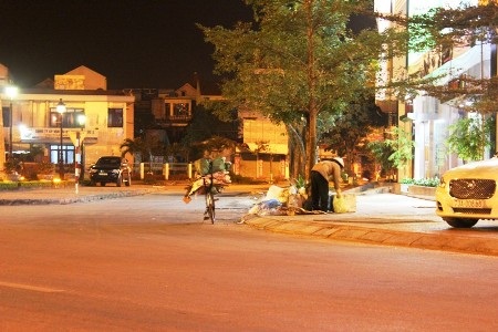 Một bà cụ đang cố gắng tìm chút may mắn trong đống rác