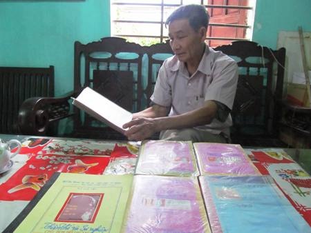 Ông Huy cùng vợ đang nghiên cứu những tài liệu, tranh ảnh về Bác