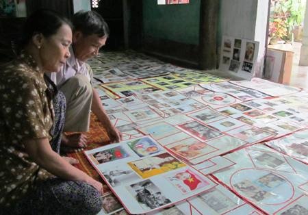 Ông Huy cùng vợ đang nghiên cứu những tài liệu, tranh ảnh về Bác