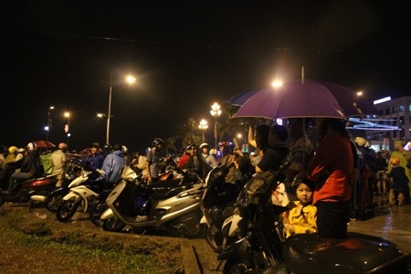 Hàng ngàn người dân đội mưa tập trung bên cầu Nhật Lệ để xem bắn pháo hoa