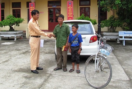 Đại diện Phòng CSGT Công an tỉnh Quảng Bình bàn giao bé Đạt cho gia đình 