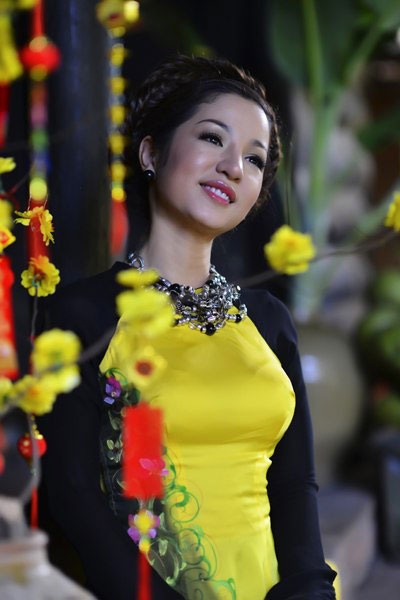 Danh hài Thúy Nga kể chuyện những cái Tết “lang bạt kỳ hồ” - 1 Thúy Nga duyên dáng trong tà áo dài bên nhành hoa mai