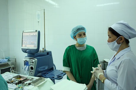 Lý Nhã Kỳ tổ chức mổ mắt cho 300 bệnh nhân đục thủy tinh thể - 3 Lý Nhã Kỳ khoác áo xanh tới từng giường bệnh của bệnh nhân động viên, chia sẻ với họ trước ca mổ