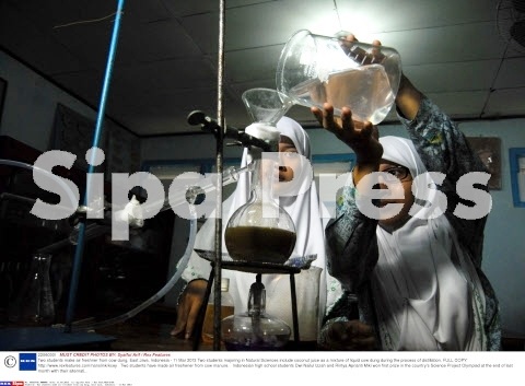 Biến phân bò thành nước khử mùi - 2 Hai học sinh thực hiện quy trình trưng cất.