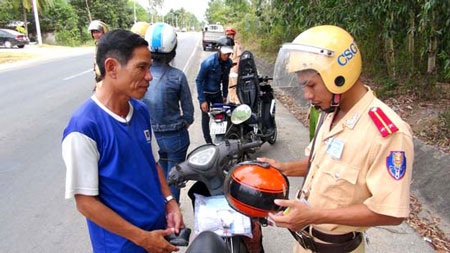 Gần 900.000 trường hợp bị xử phạt vì không đội mũ bảo hiểm - 1 CSGT xử phạt người tham gia giao thông đội mũ không phải MBH (ảnh: Báo Quảng Ngãi)