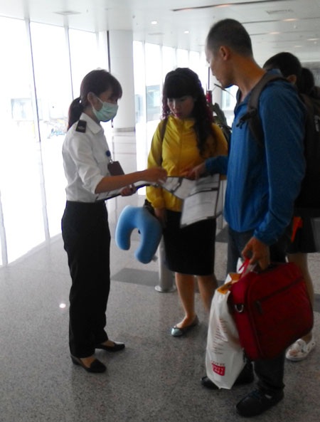 Ứng phó với dịch Mers tại sân bay quốc tế Nội Bài - 2 Nhân viên y tế phát tờ khai cho hành khách trên các chuyến bay quốc tế đến Nội Bài