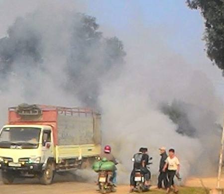 Xe tải đang chạy bốc khói nghi ngút, cả khu dân cư mịt mù - 3 Người đi đường không thể lưu thông trên đường.