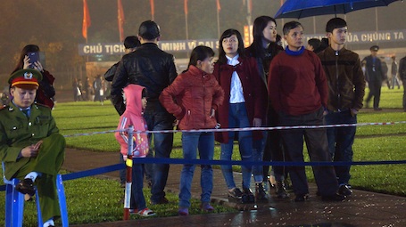 Người dân đội mưa đưa con nhỏ đến xem đêm Hội giao thừa (Ảnh: Nguyễn Duy).