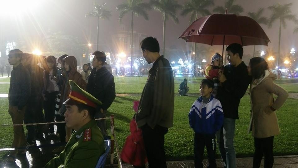 Người dân đội mưa đưa con nhỏ đến xem đêm Hội giao thừa (Ảnh: Nguyễn Duy).