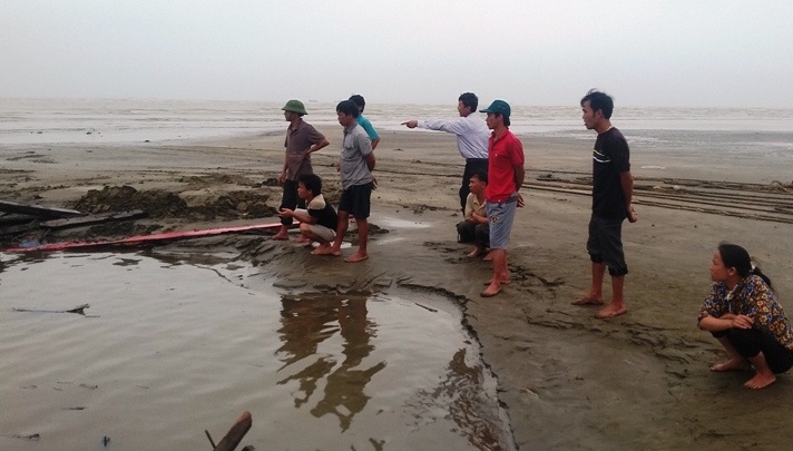 Một ngư dân 20 ngày bị sóng đánh chìm 5 con tàu - 3 Người dân theo dõi cảnh trục vớt con tàu gia đình ông Đồng vào sáng 7/4.