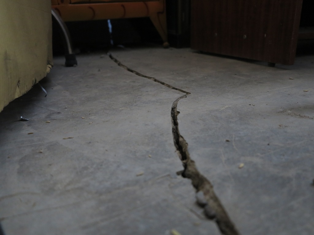 Phần nền nhà cũng xuất hiện nhiều vết nứt lớn, kéo dài.