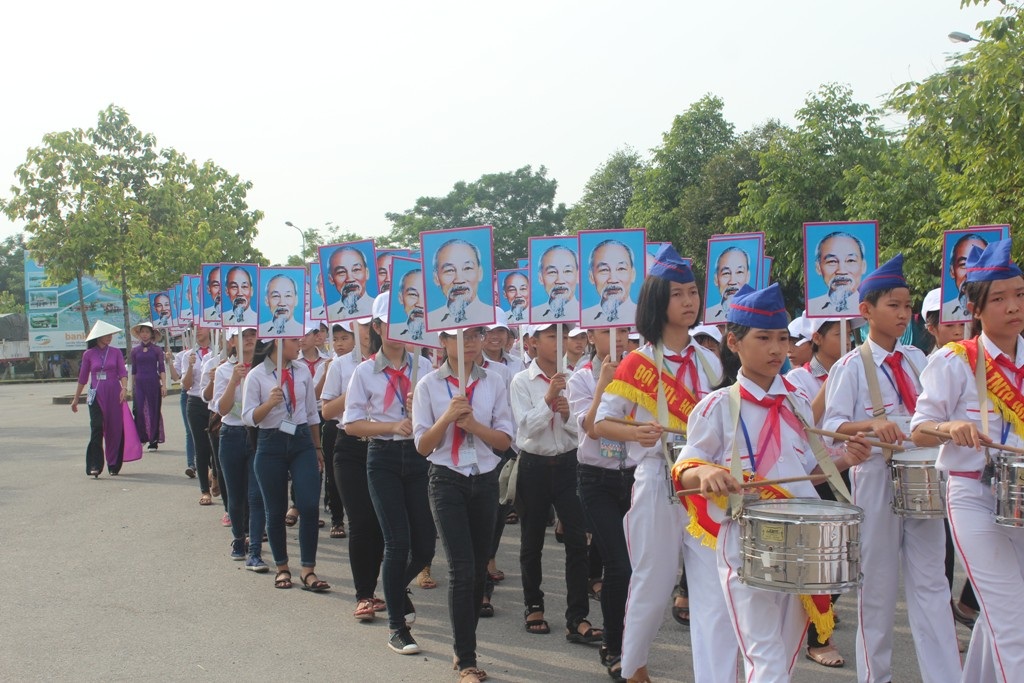 Đôi TNTP dẫn đầu đoàn rước với bức chân dung của Bác.