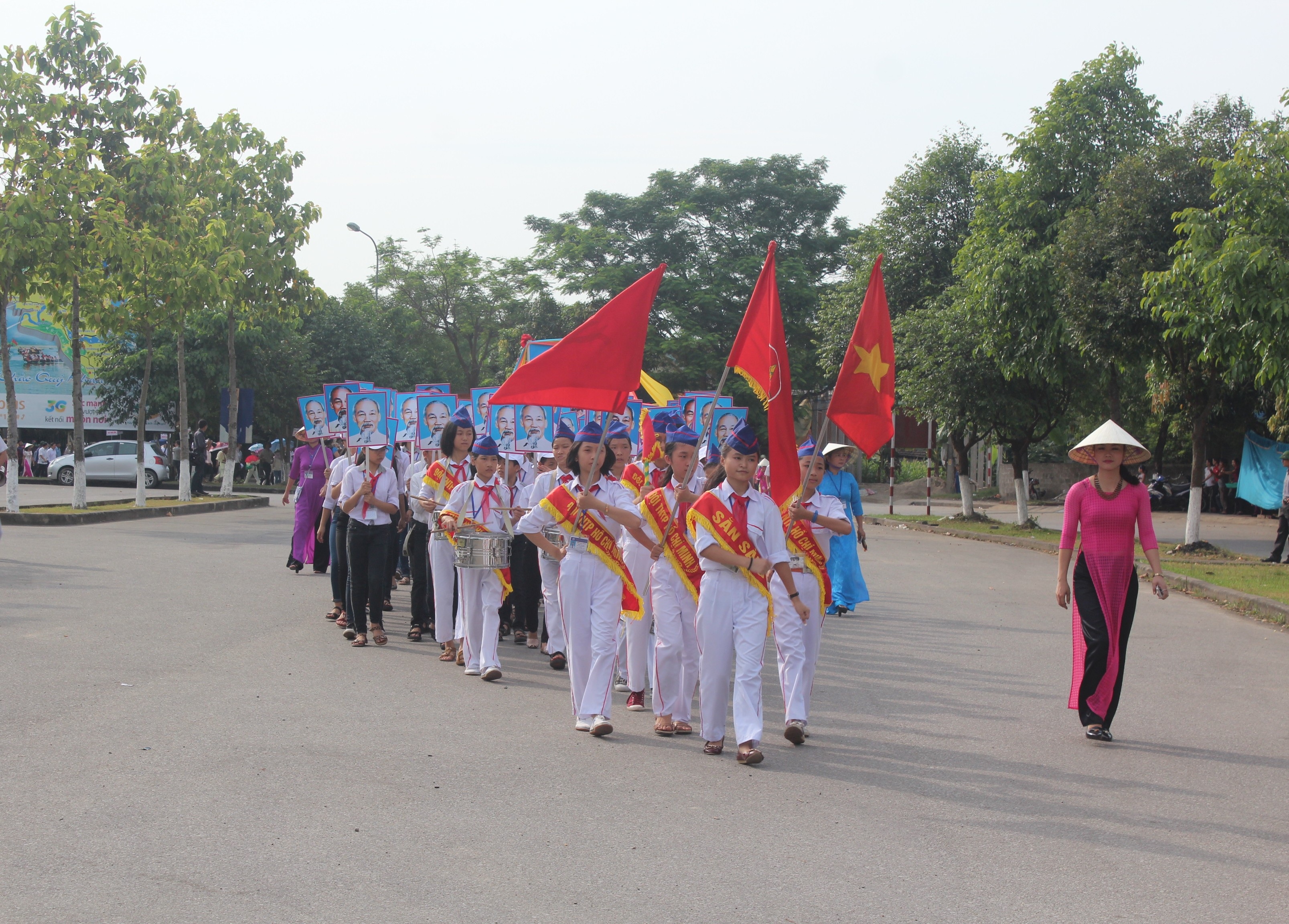 Đôi TNTP dẫn đầu đoàn rước với bức chân dung của Bác.