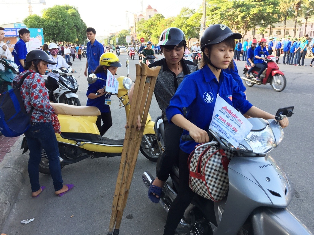 SVTN dùng xe máy trong đội xe ôm miễn phí chở Tuấn về nhà trọ.