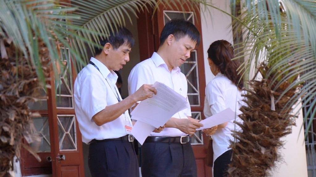 Cán bộ làm nhiệm vụ trao đổi trước giờ làm thủ tục.