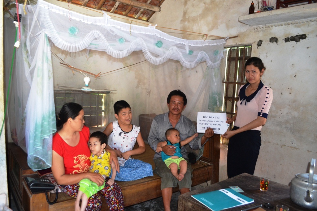 Bà Vũ Thị Hằng - cán bộ chính sách xã Diễn Lâm thay mặt PV Dân trí trao quà đến gia đình chị Thắng.