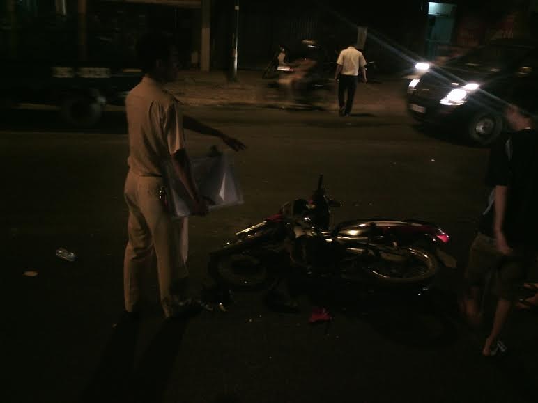 Chiếc xe máy hư hỏng nặng nằm sóng soài giữa đường.