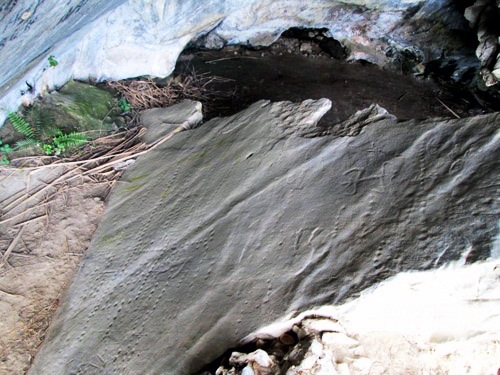 Phiến đá có khắc các hình người và hình lõm được phát hiện tại hang Bò, xã Hoa Sơn, huyện Anh Sơn.