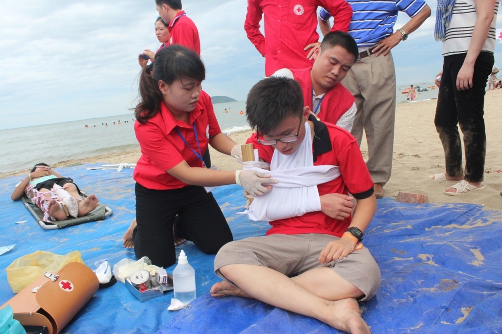 Một nạn nhân bị thương trong khi chằng chống nhà cửa được băng bó, cố định vết thương.