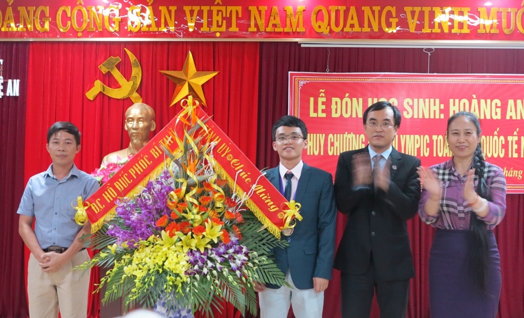  Lãnh đạo UBND tỉnh Nghệ An tặng hoa chúc mừng cậu học trò giành HCB sau 18 năm chờ đợi.