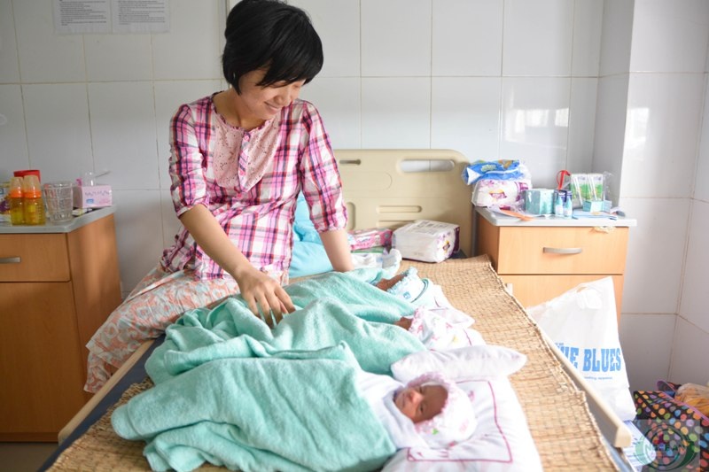 Sản phụ Chế Thị Huyền bên ba đứa con gái của mình.