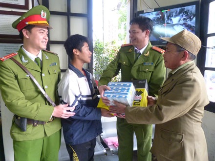 Công an Hà Nội giúp cậu bé “hay quên” tìm được người thân - 1 Long được gia đình đến đón về và nhận phần quà từ tay các chú CA.