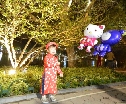 Cháu bé tạo dáng bên bờ hồ Hoàn Kiếm để bố mẹ chụp ảnh.